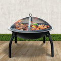 Outdoor fire pit with grill mesh lid, perfect for backyard BBQs and garden gatherings