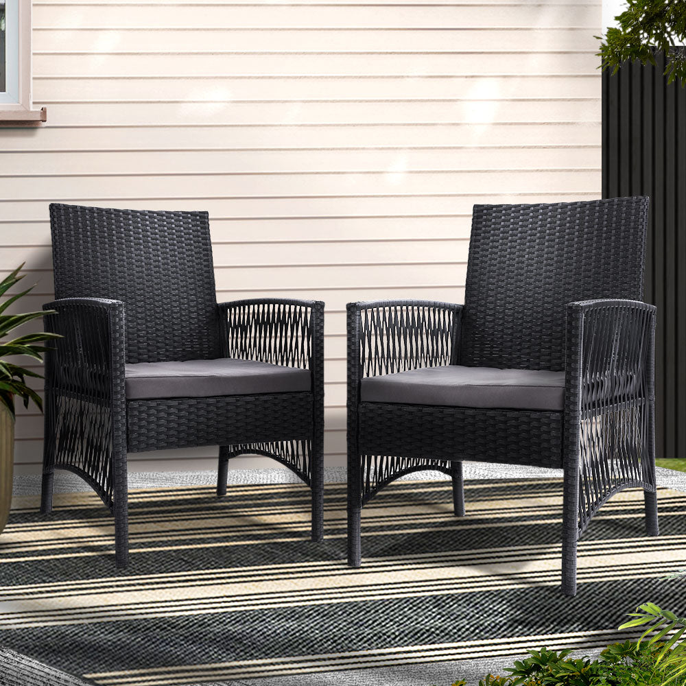 Black wicker outdoor armchairs with grey cushions on striped patio rug, perfect for Australian backyards.