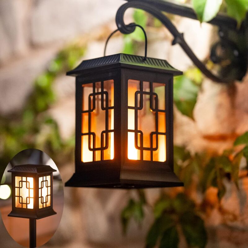Black solar lantern with geometric pattern, glowing warmly for outdoor garden lighting