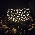 Garden lighting with leaf-cut pattern glowing on pebbles, perfect for outdoor ambiance