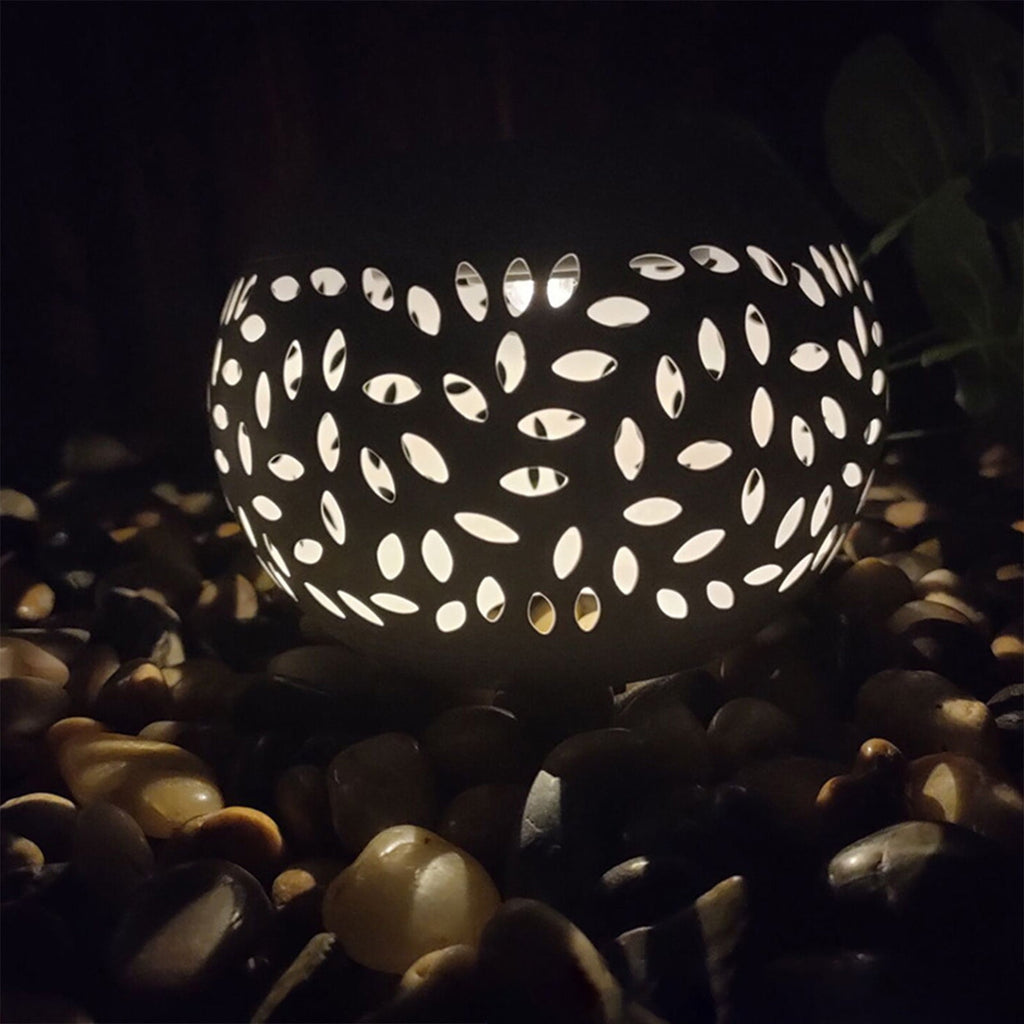 Garden lighting with leaf-cut pattern glowing on pebbles, perfect for outdoor ambiance
